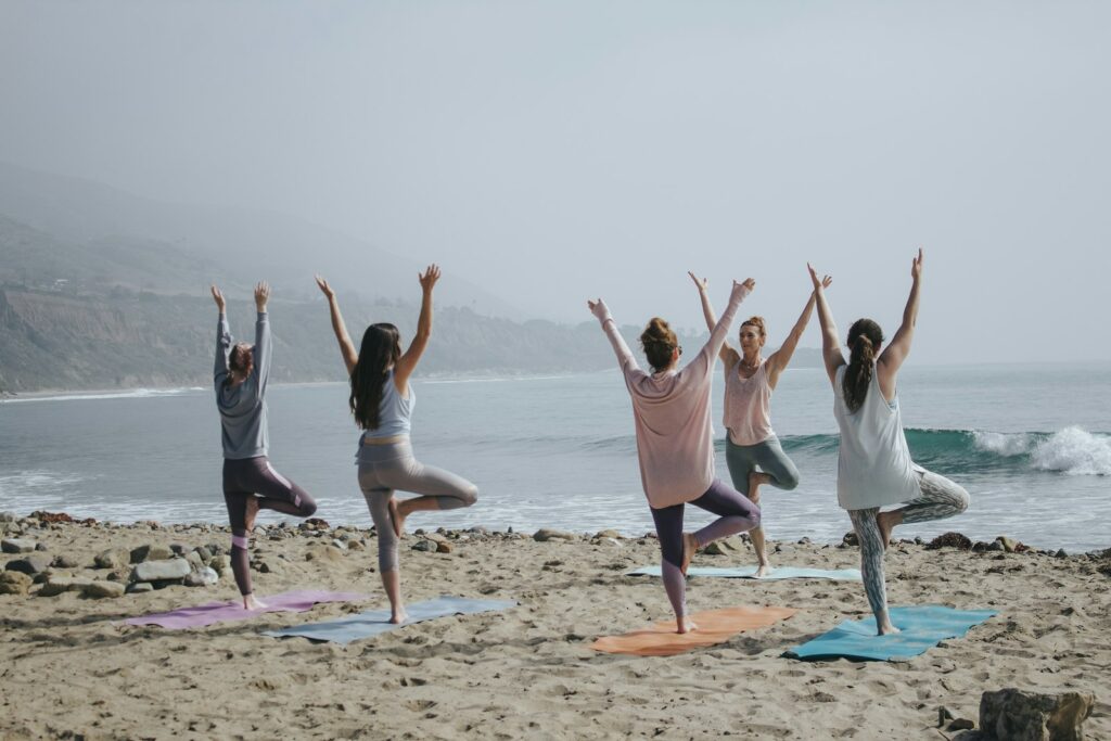 Gruppo in pratica yoga all'alba sulla spiaggia del Poetto a Cagliari